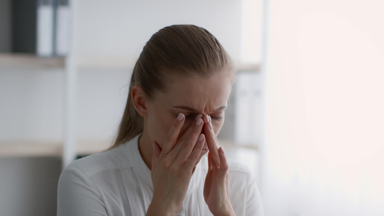 mujer con dolor de cabeza en la oficina