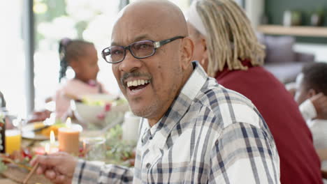 Retrato-De-Un-Abuelo-Afroamericano-Con-Su-Familia-En-La-Mesa-De-La-Cena-De-Acción-De-Gracias,-Cámara-Lenta