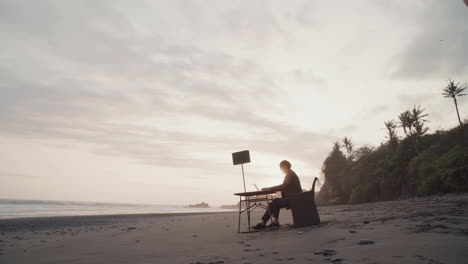 man working on beach at sunset