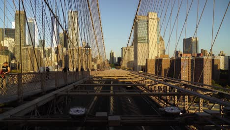 busy cars traffic through brooklyn bridge to lower manhattan on a sunny evening in new york