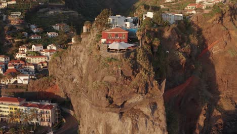 ciudad costera pintoresca con edificios en la cima de una cordillera y en el valle durante la puesta de sol en ponta do sol, madeira, portugal