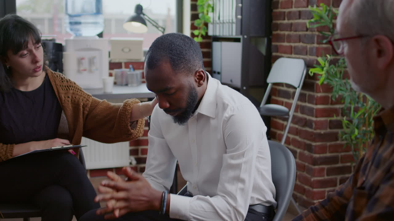 Desperate man making confession in front of people with addiction at aa support group meeting