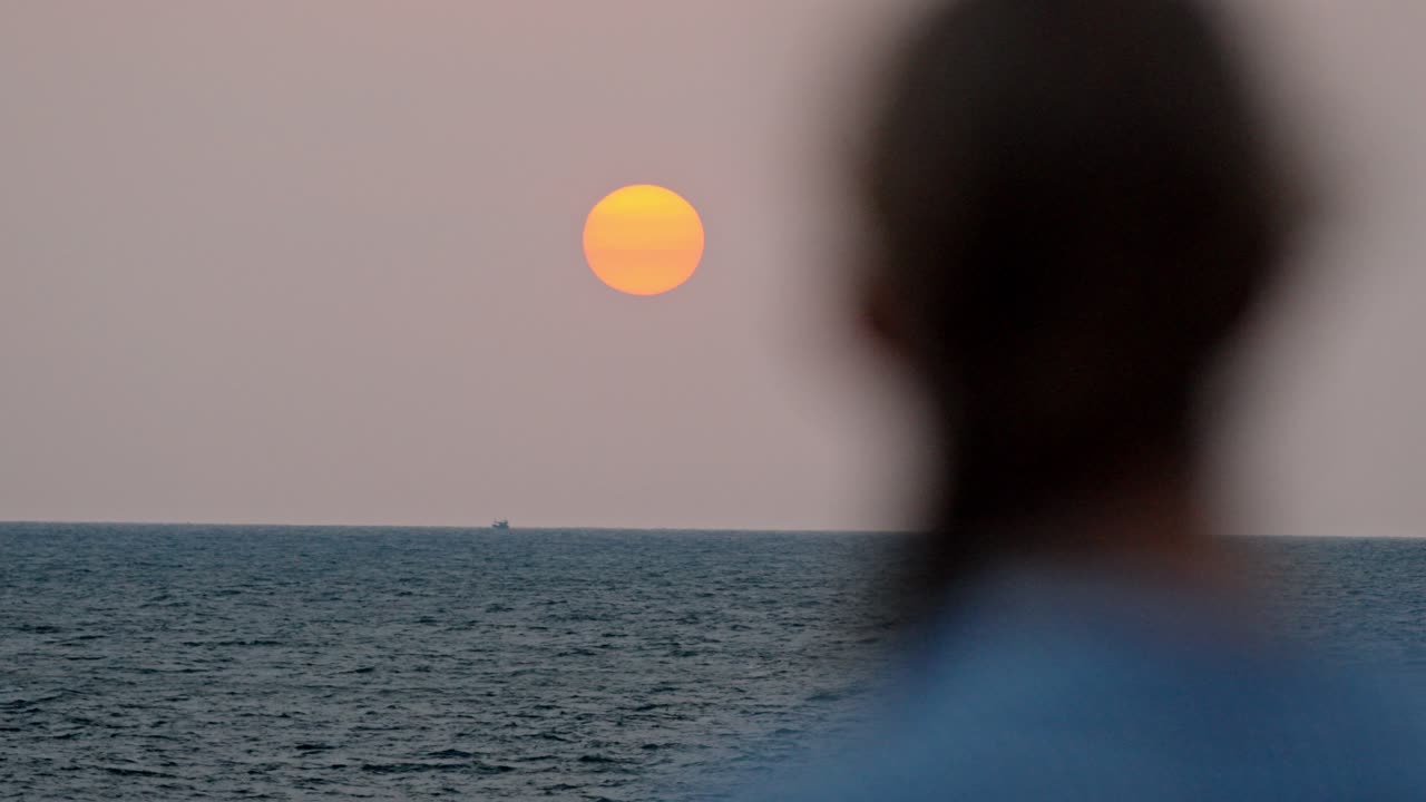 A serene moment in Galle, Sri Lanka, as a woman gazes at the vast ocean during a breathtaking sunset.