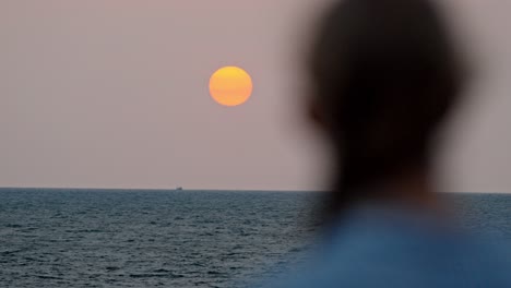 a serene moment in galle, sri lanka, as a woman gazes at the vast ocean during a breathtaking sunset.
