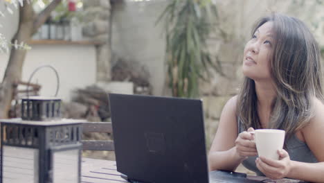 woman having video call while sitting at table in outdoor cafe