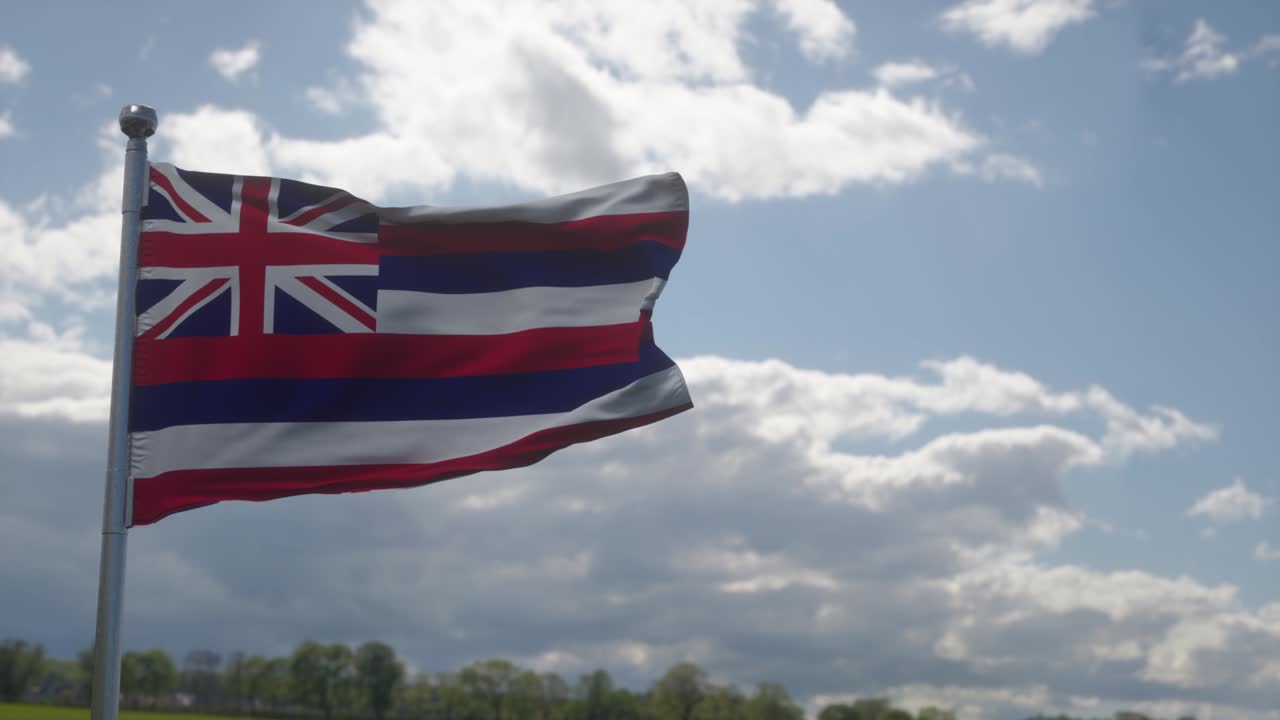 Gökyüzünde rüzgarda dalgalanan bayrak direğindeki Hawaii bayrağı. Amerika Birleşik Devletleri'ndeki Hawaii Eyaleti.