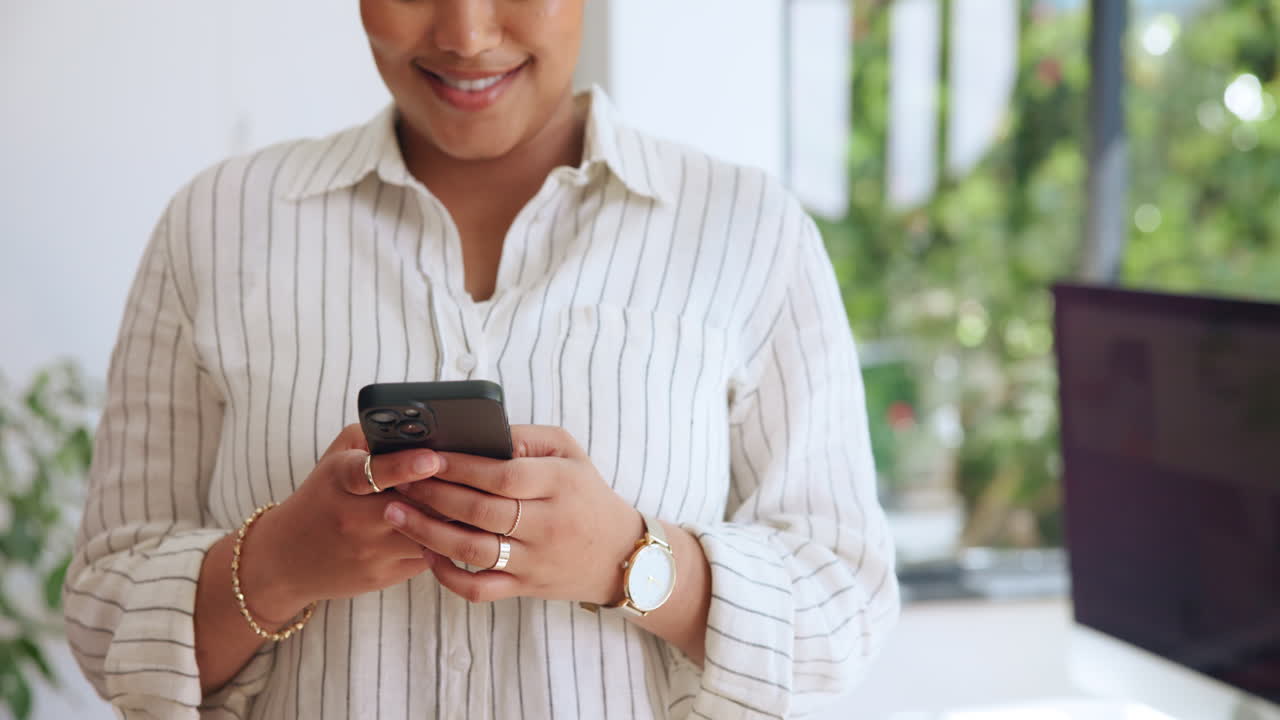 Young Woman Texting and Smiling on Smartphone in Office