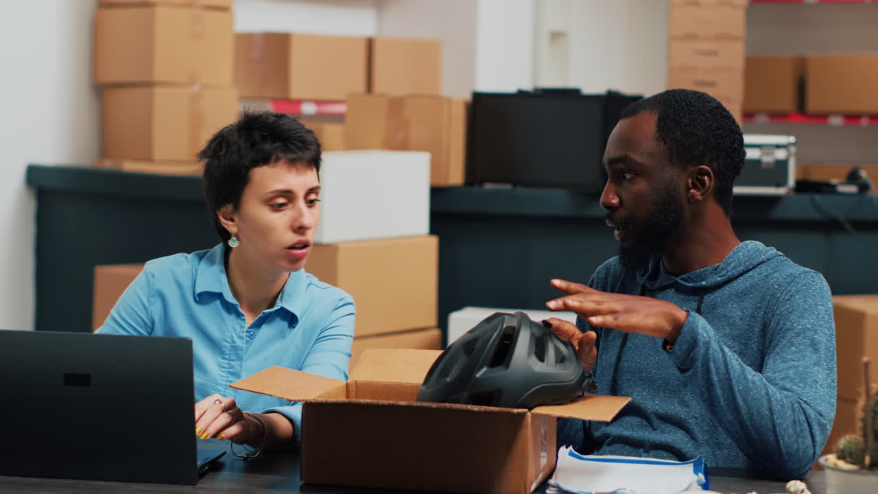 People working in a warehouse with boxes and laptop