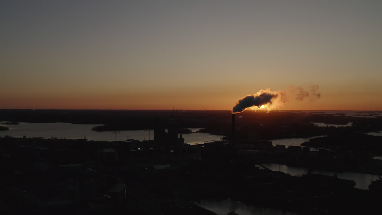 Industrial chimney exhaust smoke hides the sun. Air Pollution. Sunset