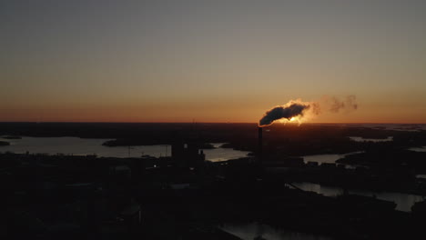 industrial chimney exhaust smoke hides the sun. air pollution. sunset