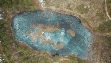 AERIAL:-Bright-Blue-Ice-Swamp-Lake-in-Forest-in-Lithuania