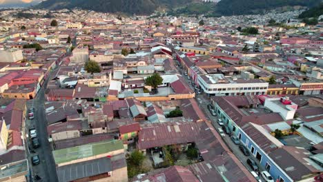 Drohnen-Luftaufnahme-Von-Städtischen-Kolonialviertelgebäuden-Und-Straßen-In-Quetzaltenango-Xela-Guatemala-Während-Des-Sonnenuntergangs-Zur-Goldenen-Stunde