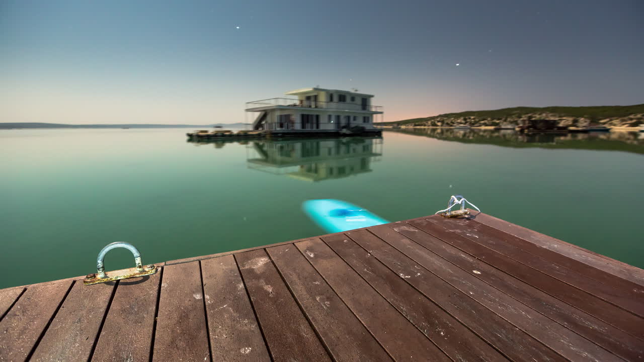 A static Time-Lapse captured from a houseboat at night time showing natural movement of the surrounds from the tide and currents.