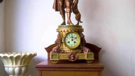 Reveal-shot-of-antique-vintage-clocks-with-copper-statue-of-a-dog-and-sheperd-on-a-white-backround-wall-slow-motion