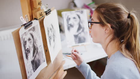 Artista-Adolescente-Sentada-En-Un-Caballete-Dibujando-Un-Perro-A-Partir-De-Una-Fotografía-Con-Carbón
