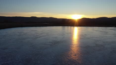puesta de sol de invierno sobre el lago congelado y el pantano
