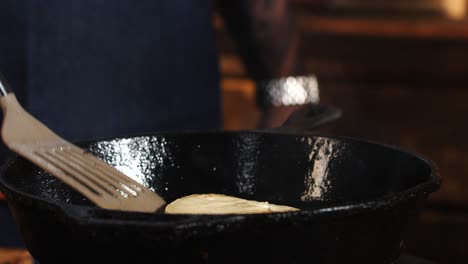 chef frying food in cast iron pan