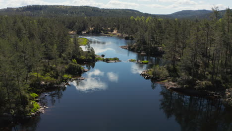 aerial view overlooking a reflecting river in fidjetun, south norway - tracking, drone shot