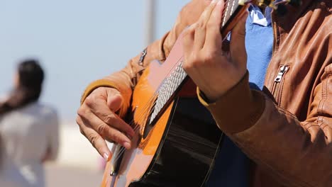 Primer-Plano-De-Un-Joven-Tocando-La-Guitarra