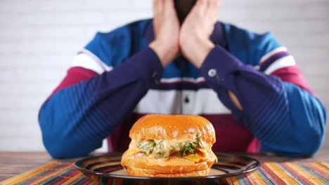 man looking disappointed at his burger