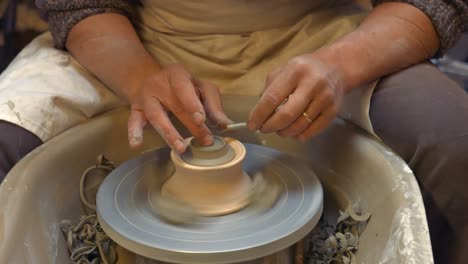 potter making a earthen pot on a pottery wheel