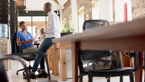 Young-African-American-business-couple-engaged-in-a-serious-conversation-at-the-office-with-copy-spa