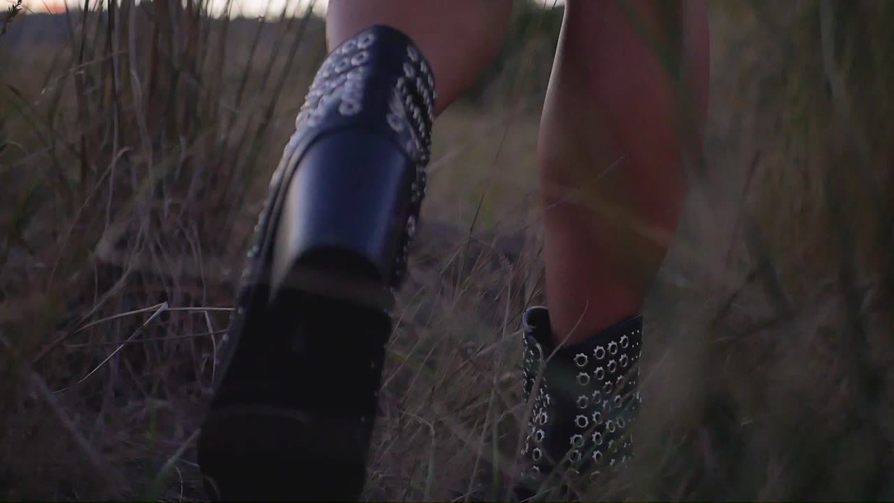 Girls feet walking in a field with shallow depth of field follow shot