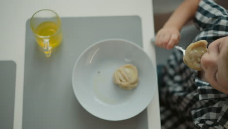 child eating dumplings