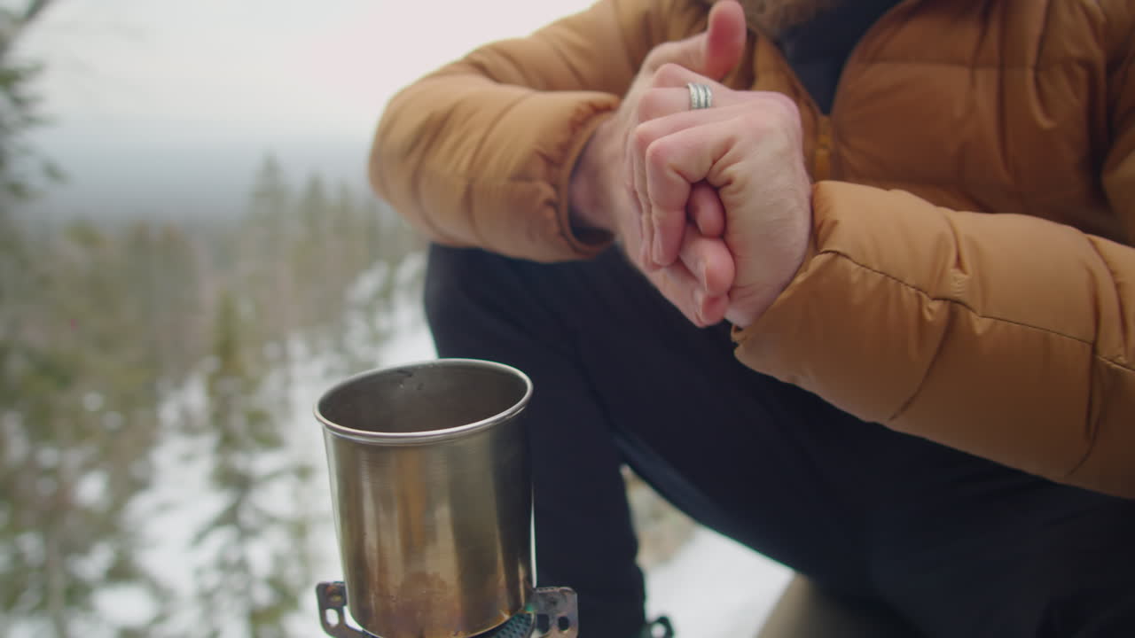 Man Warming near Gas Stove at Campsite on Winter Day