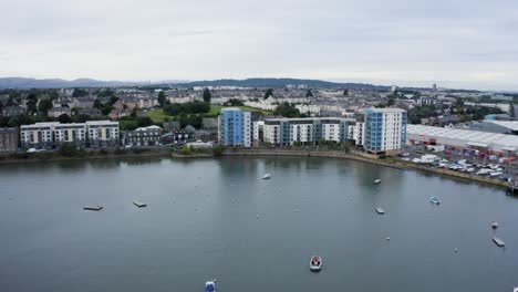 yates caros, embarcaciones de recreo y catamaranes atracados en un puerto deportivo de la ciudad junto a un bloque de apartamentos caro | newhaven, edimburgo, escocia | 4k a 30fps