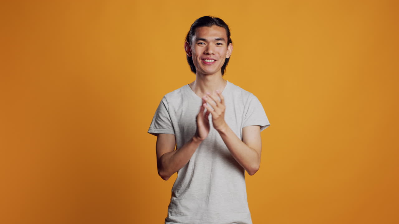 Smiling person clapping hands in studio