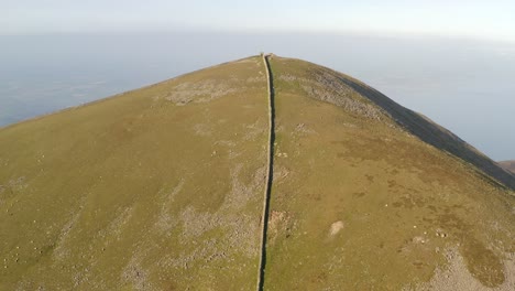 Mourne-wall-water-management-in-north-of-ireland-on-Slieve-Donard,-symmetry-and-shadows-at-sunrise