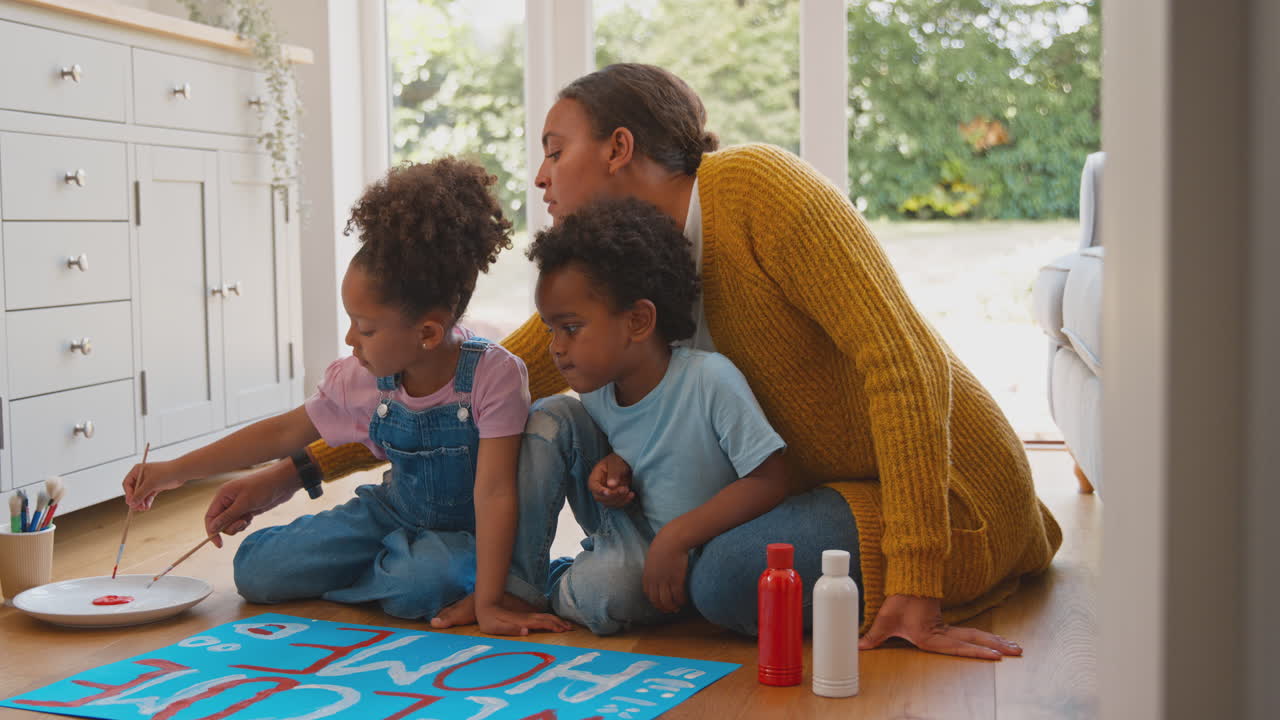 Pregnant Mother With Children Making Welcome Home Banner For Army Father