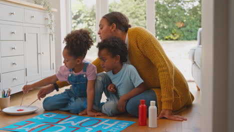 pregnant mother with children making welcome home banner for army father
