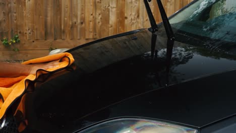 Person-drying-their-car-bonnet-after-washing-with-a-micro-fibre-towel