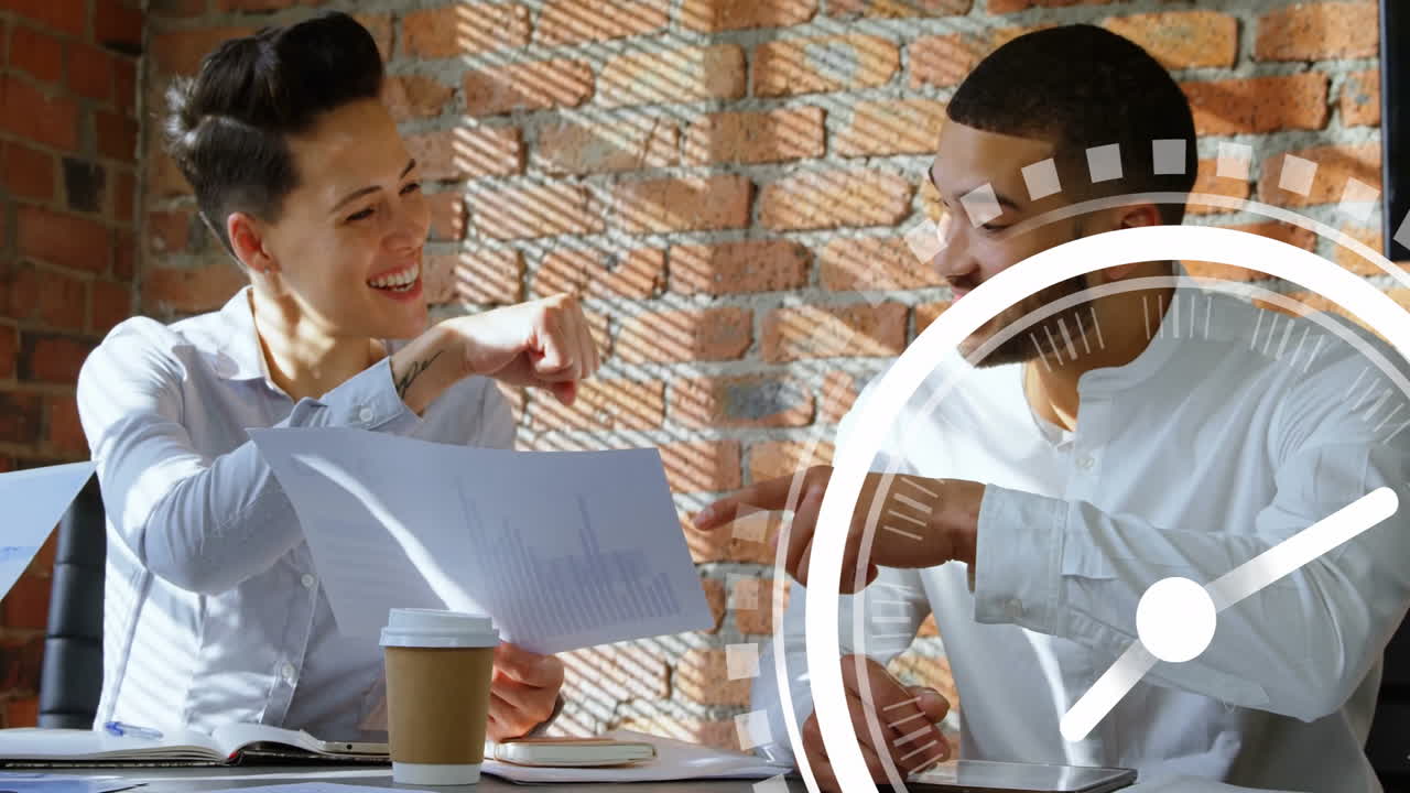 Two colleagues discussing documents at table with clock animation overlay