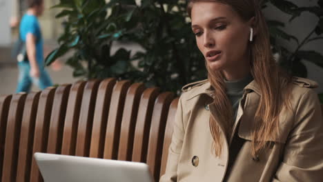 caucasian female video calling on laptop outdoors.