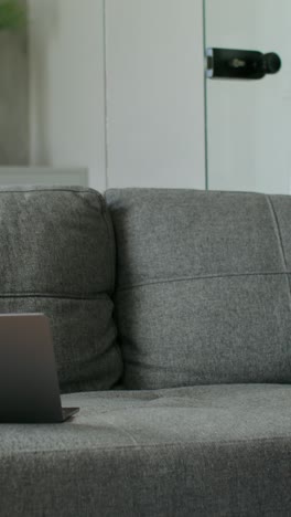 man relaxing on couch with laptop and phone