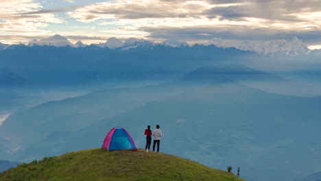 couple enjoys camping in hills of sailung, dolakha, nepal, stunning horizon views of mountain ranges nea tibet border serene nature and heavenly tenting create a perfect escape together drone shot