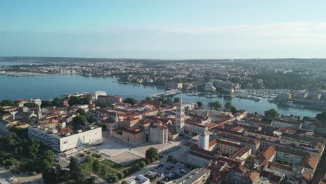 zadar en una mañana de verano, una grabación de un avión no tripulado volando hacia atrás y revelando el foro romano con la iglesia de san