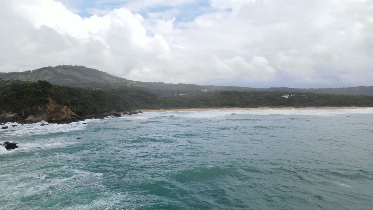 Veduta panoramica della spiaggia con montagne, cielo blu e nuvole a Sapphire Beach, Coffs Harbour, NSW, Australia - ripresa aerea in allontanamento