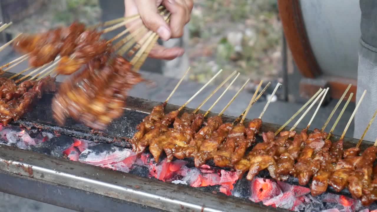 Chicken satay cooking process. Grilled chicken over coals. Indonesian food concept