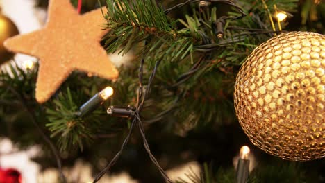 Goldene-Weihnachtskugeldekoration-Auf-Tannenbaum.Feiertage,-Neujahr-Und-Festkonzept-–-Goldene-Weihnachtskugeldekoration-Mit-Funkelnden-Girlandenlichtern-Auf-Künstlichem-Tannenbaum