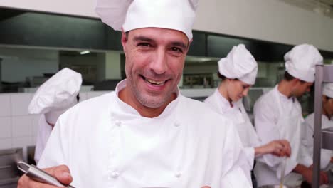chef guapo batiendo huevos en un tazón