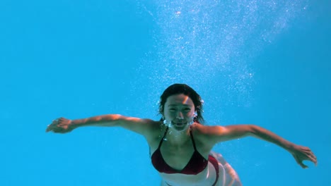 happy brunette underwater in swimming pool