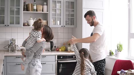 Young-family-with-two-daughters-are-dancing-on-the-kitchen