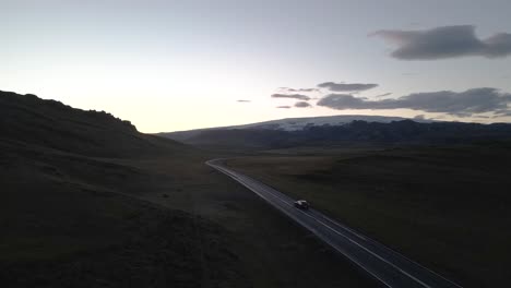 description: in this captivating 4k drone footage, a car journeys into the sunset, tracing a path along a mountainside, embodying the spirit of adventure