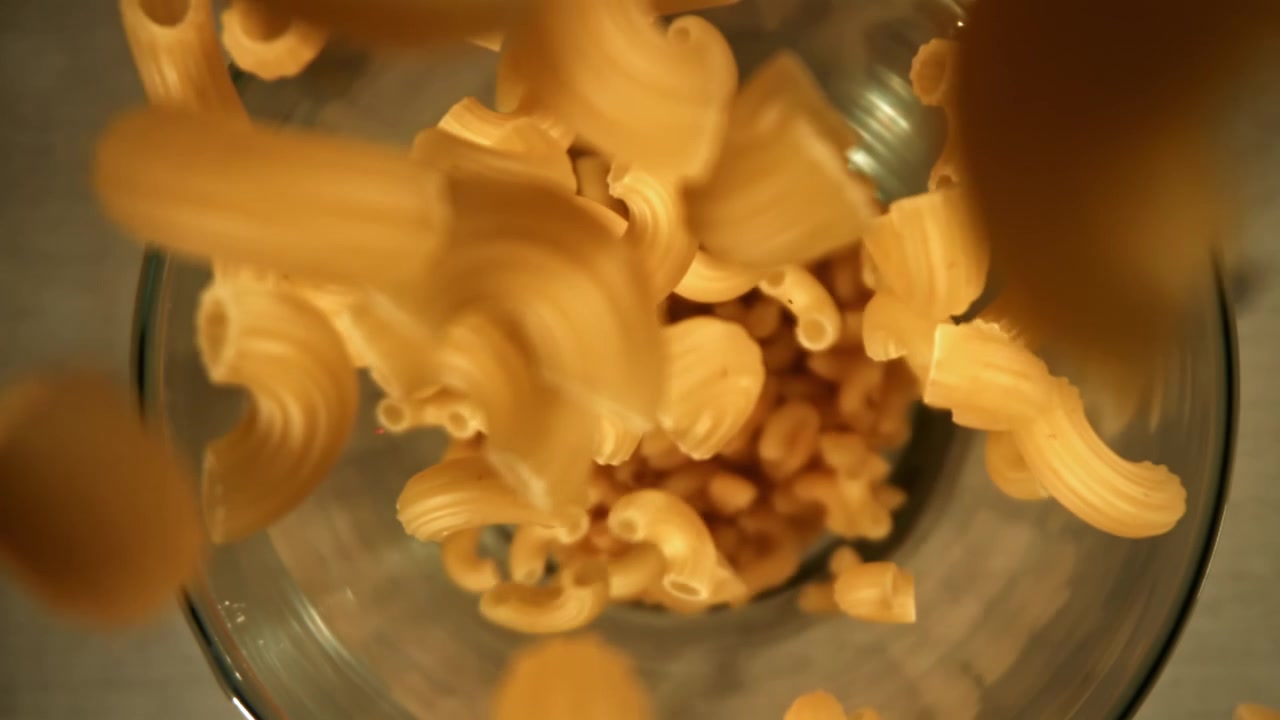 Maccheroni che cadono in una ciotola di vetro al rallentatore