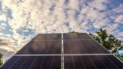 Looking-up-at-white-clouds-drifting-past-in-a-blue-sky-over-solar-panels