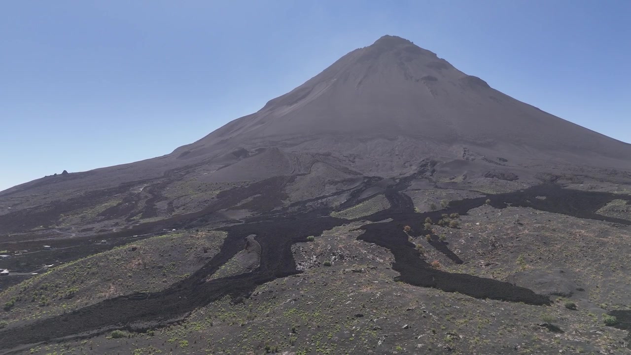Veduta aerea di sentieri di lava solidificata che si fanno strada attraverso il terreno vulcanico scuro, conducendo verso la base del Pico do Fogo nella regione di Chã das Caldeiras, Capo Verde.